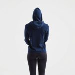 A model wearing a navy blue black activewear jacket lounge hoodie, back view, studio shot on white background.