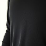 Close-up of black long sleeve activewear top fabric showing texture, stitching, and quality for gym workouts.