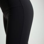 Close-up of high-waisted black seamless leggings fabric, showcasing texture and premium stitching detail.