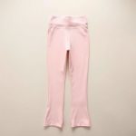 Pastel pink flare leggings woman high rise compression leggings folded neatly on a neutral surface.