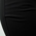 Close-up of linen fabric texture and stitching on black leggings with pockets, highlighting quality and detail.
