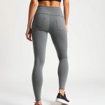 Back view of a model wearing black leggings with pockets in Heather Grey, showcasing fit on a white background.