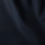 Close-up detail of organic cotton black yoga flare pants showing fabric texture and stitching.