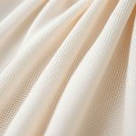 Close-up macro shot of the First Muse dress fabric texture and quality stitching.