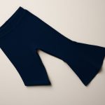 Navy Blue ribbed flared leggings woman neatly folded on a neutral surface, top-down minimalist flat lay.