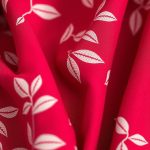 Close-up detail of the raspberry tea leaves flare pants set fabric texture and stitching.