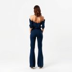 Back view of a model in a navy blue flared pants outfit, conscious clothing, on a white studio background.