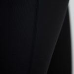 Close-up of black high waisted flare leggings fabric, showcasing recycled material texture and quality stitching.