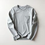 Flat lay of a Heather Grey long sleeve sports top and pocket active leggings neatly folded on a neutral surface.