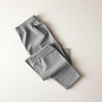 Organic cotton yoga pants in Heather Grey, neatly folded in a minimalist flat lay.