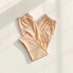 Flat lay of beige plus size yoga pants australia aura wrap, neatly folded on a clean surface.