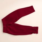 Burgundy ruched leggings with scrunch bum detail neatly folded on a neutral surface, top-down view.