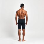 Back view of a model wearing black yoga shorts men | yoga mens clothing, showcasing fit on a white studio background.